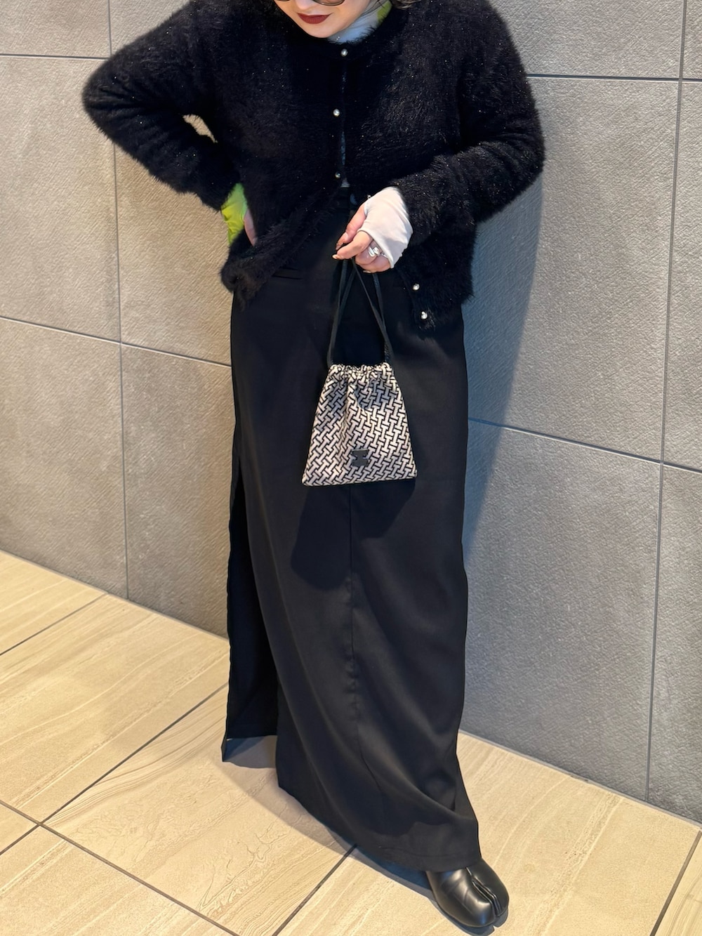 ブラック系のポーチを着用したレディースの冬コーディネートの3枚目の写真