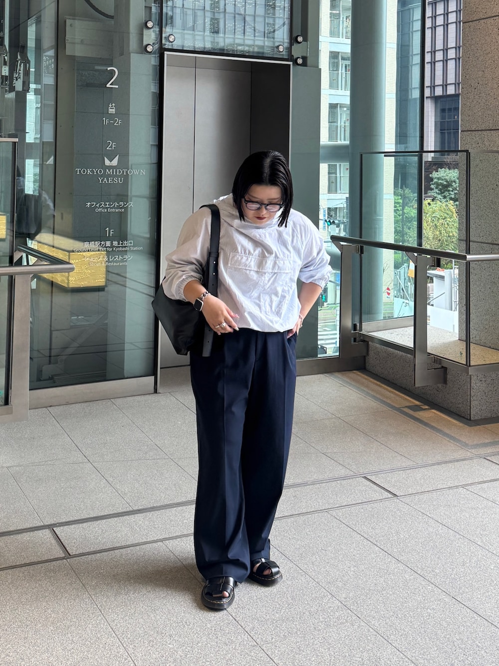 ブラック系のショルダーバッグを着用したレディースの春コーディネートの2枚目の写真