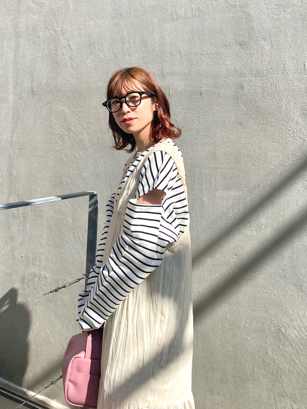 ホワイト系のTシャツ/カットソー、ホワイト系のワンピース、ベージュ系のボストンバッグを着用したレディースの冬コーディネートの2枚目の写真