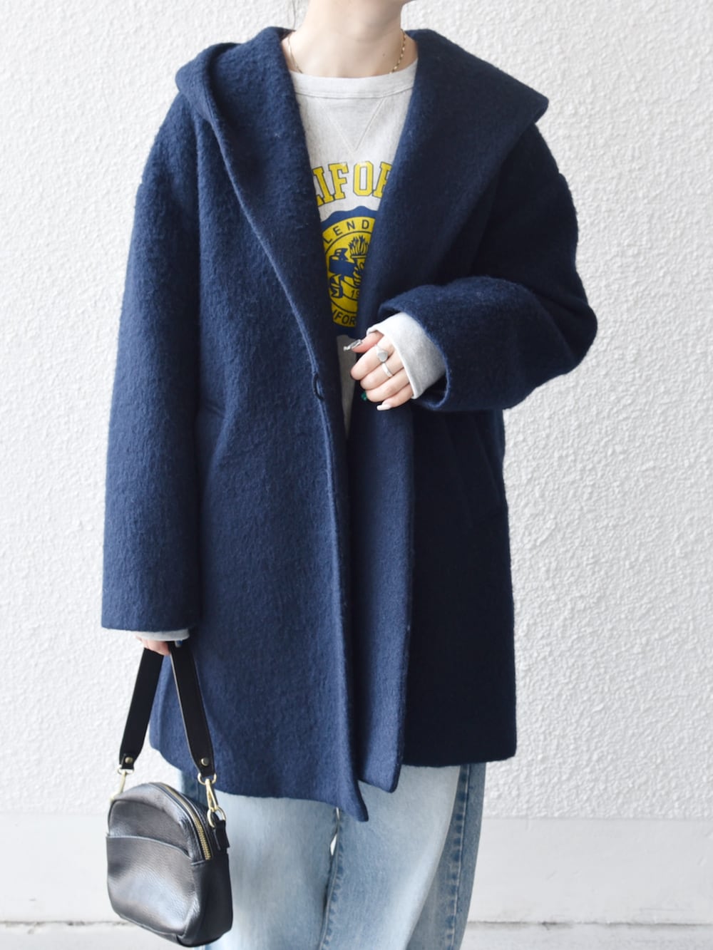 ブルー系のデニムパンツ、グレー系のスウェット、ブルー系のその他アウターを着用したレディースの秋コーディネートの2枚目の写真