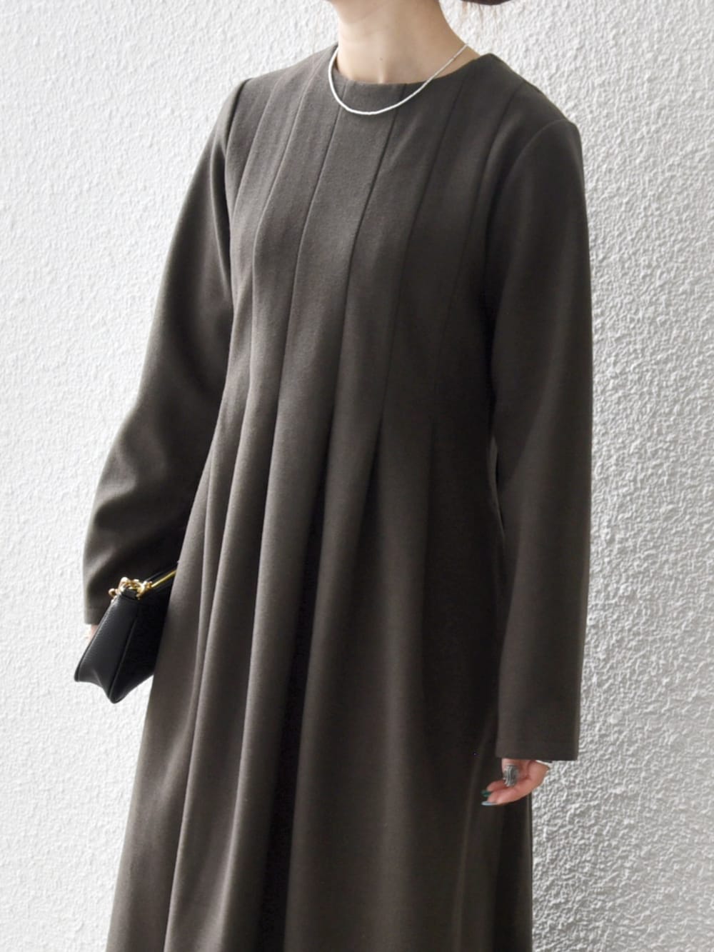 グリーン系のワンピースを着用したレディースの秋コーディネートの2枚目の写真