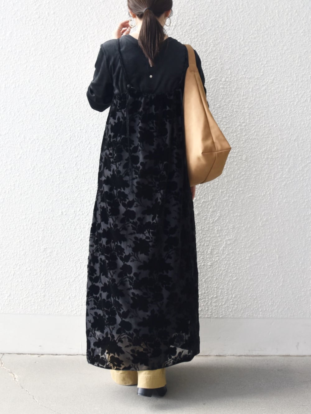 イエロー系のトートバッグ、ブラック系のTシャツ/カットソー、ベージュ系のその他パンツを着用したレディースの冬コーディネートの3枚目の写真