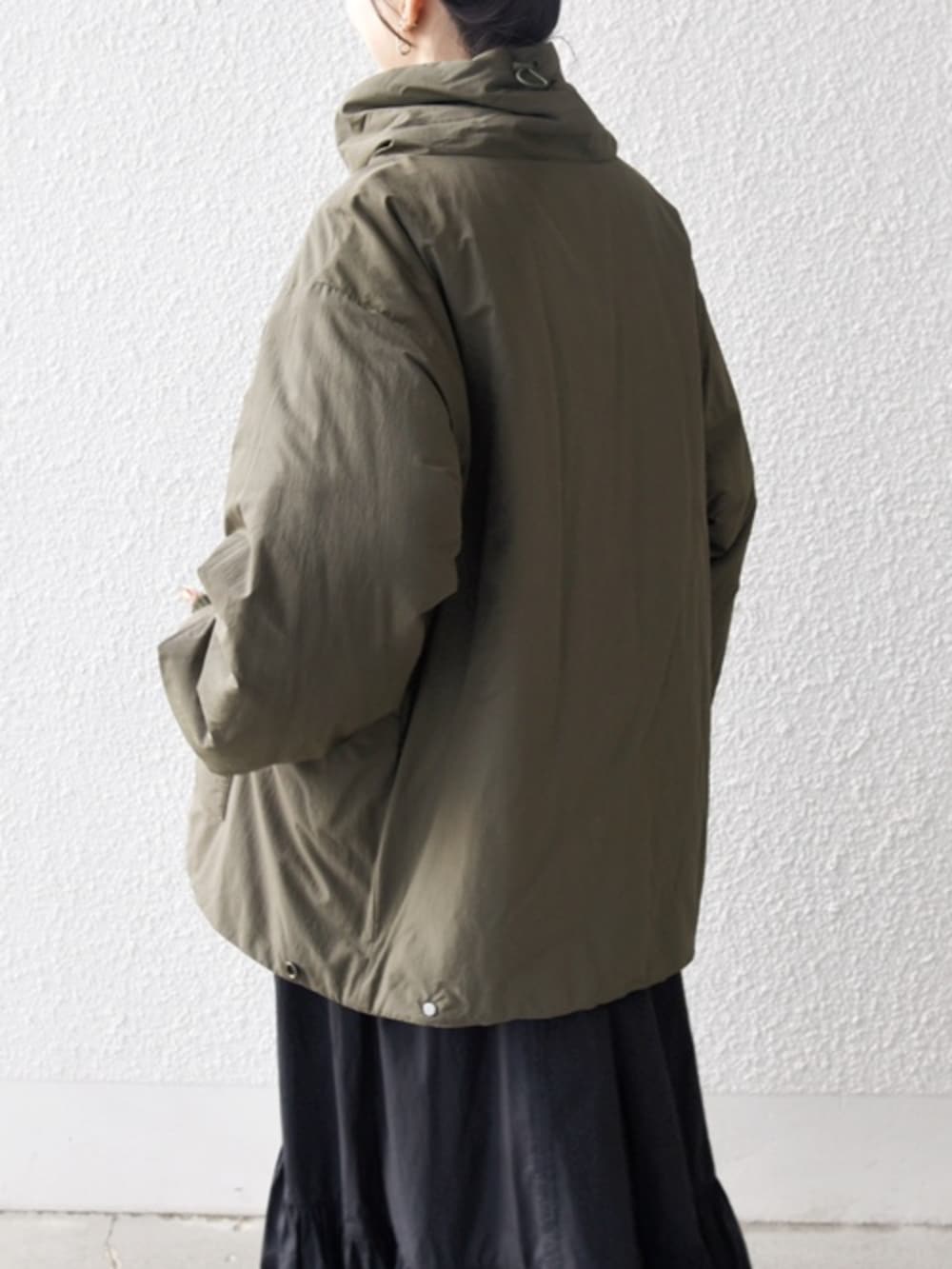 ブラック系のブーツ、ブラック系のボストンバッグ、グリーン系のブルゾンを着用したレディースの冬コーディネートの3枚目の写真