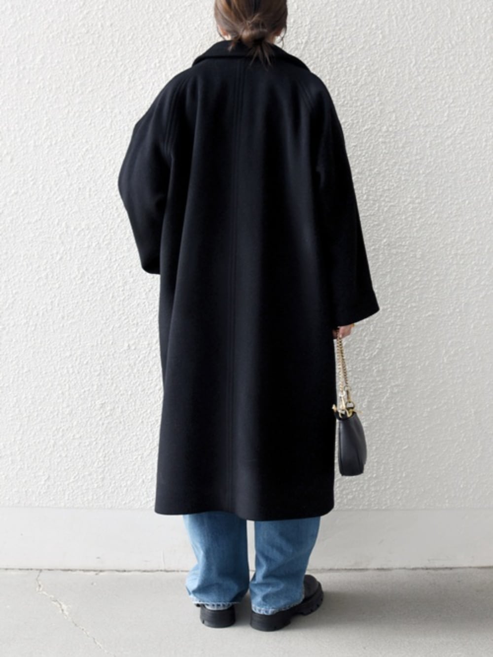 ブルー系のデニムパンツ、ブルー系のシャツ/ブラウス、ブラック系のステンカラーコートを着用したレディースの冬コーディネートの3枚目の写真