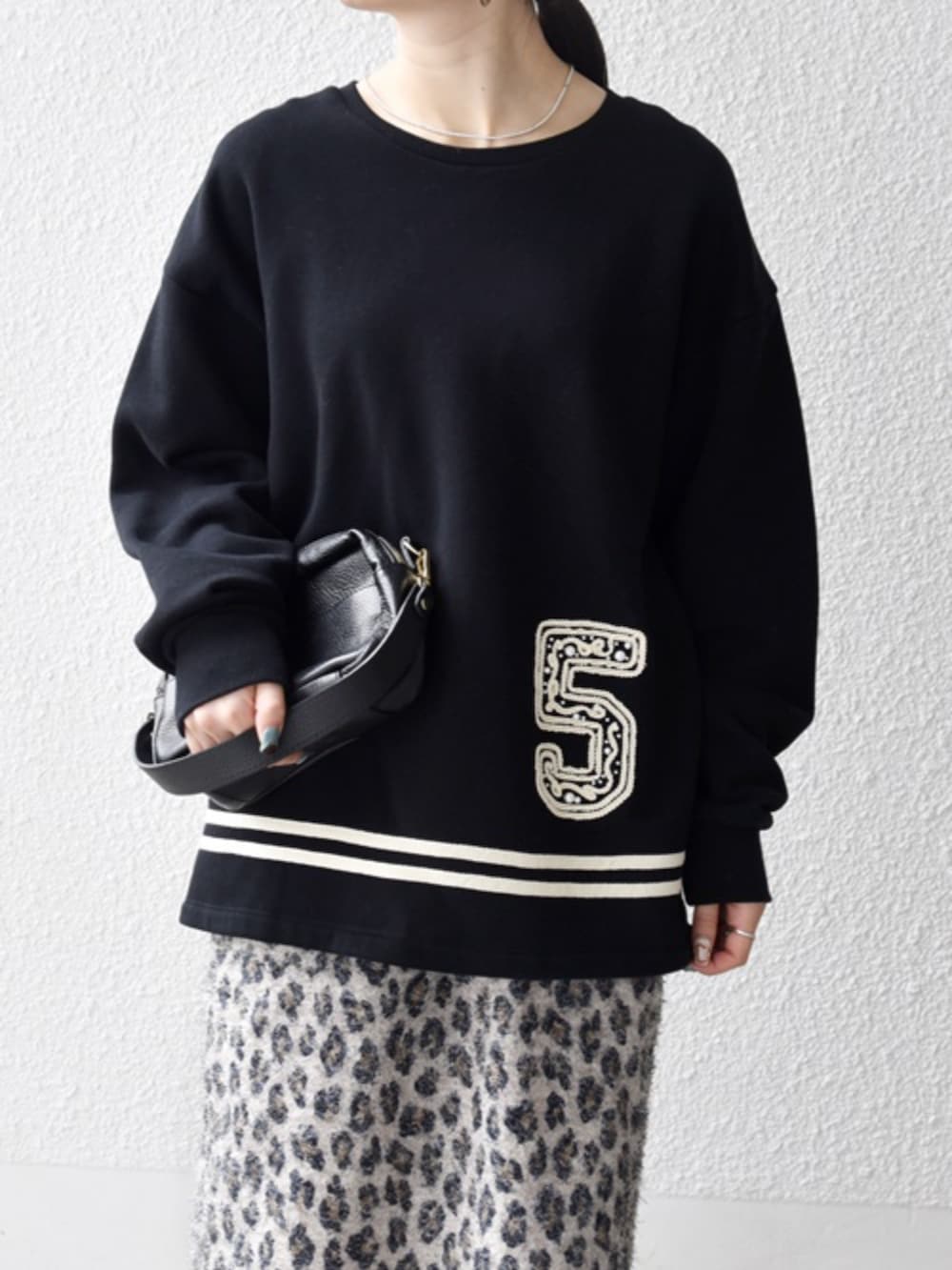 ベージュ系のスカート、ブラック系のスウェットを着用したレディースの秋コーディネートの2枚目の写真