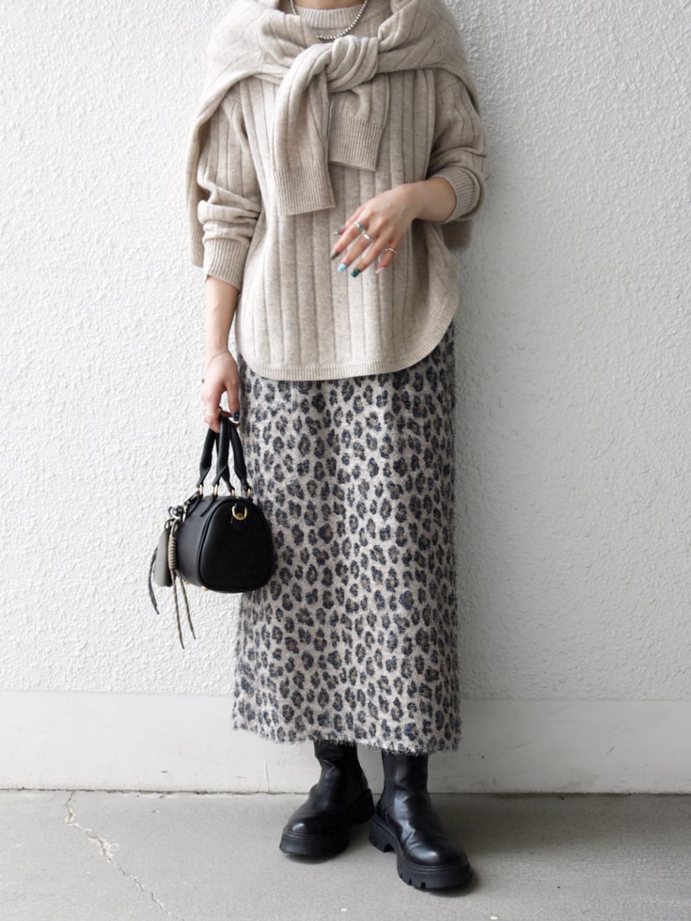 ブラック系のボストンバッグ、ベージュ系のカーディガン/ボレロ、ベージュ系のスカートを着用したレディースの秋コーディネートの2枚目の写真