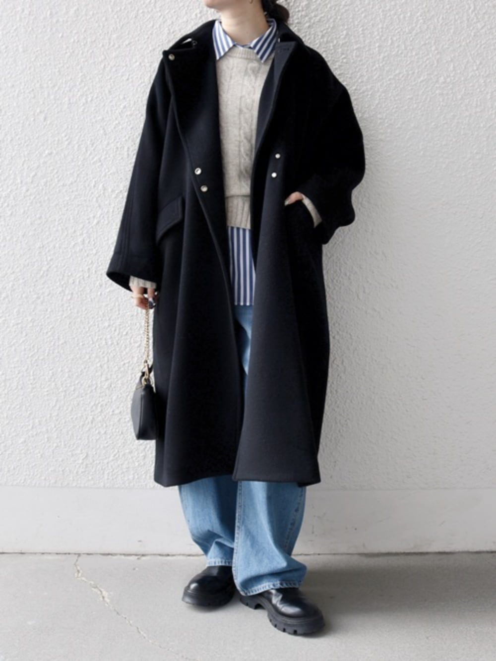 ブルー系のデニムパンツ、ブルー系のシャツ/ブラウス、ブラック系のステンカラーコートを着用したレディースの冬コーディネートの2枚目の写真