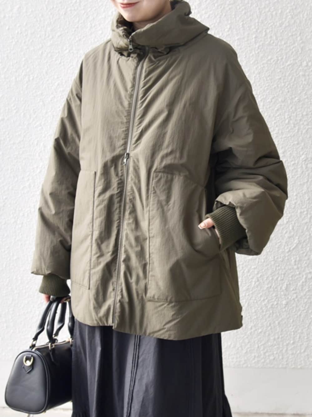 ブラック系のブーツ、ブラック系のボストンバッグ、グリーン系のブルゾンを着用したレディースの冬コーディネートの4枚目の写真