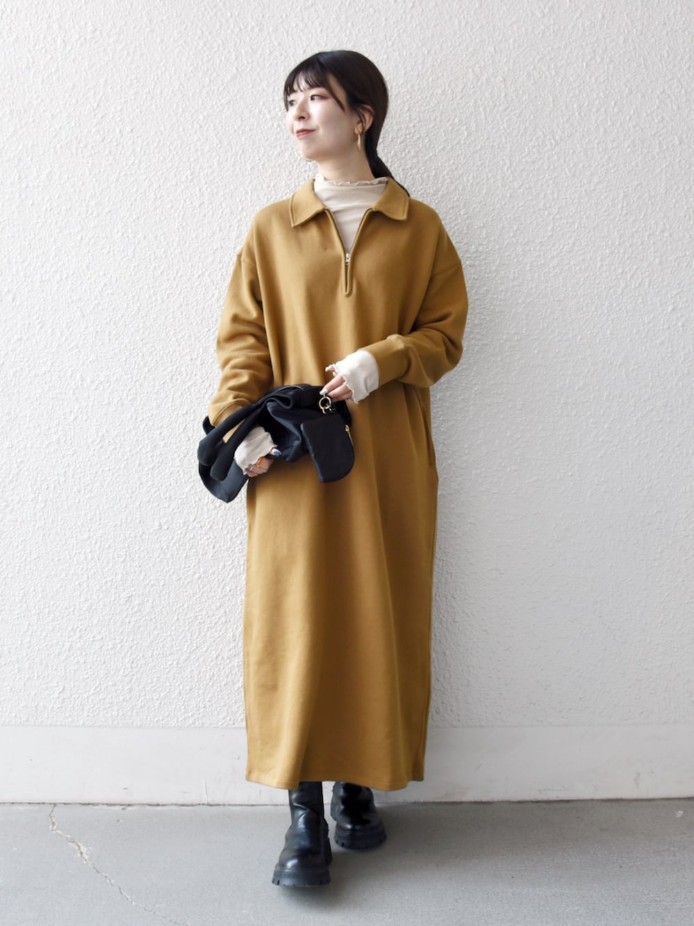 ブラック系のブーツ、イエロー系のワンピース、ブラック系のトートバッグを着用したレディースの秋コーディネートの2枚目の写真