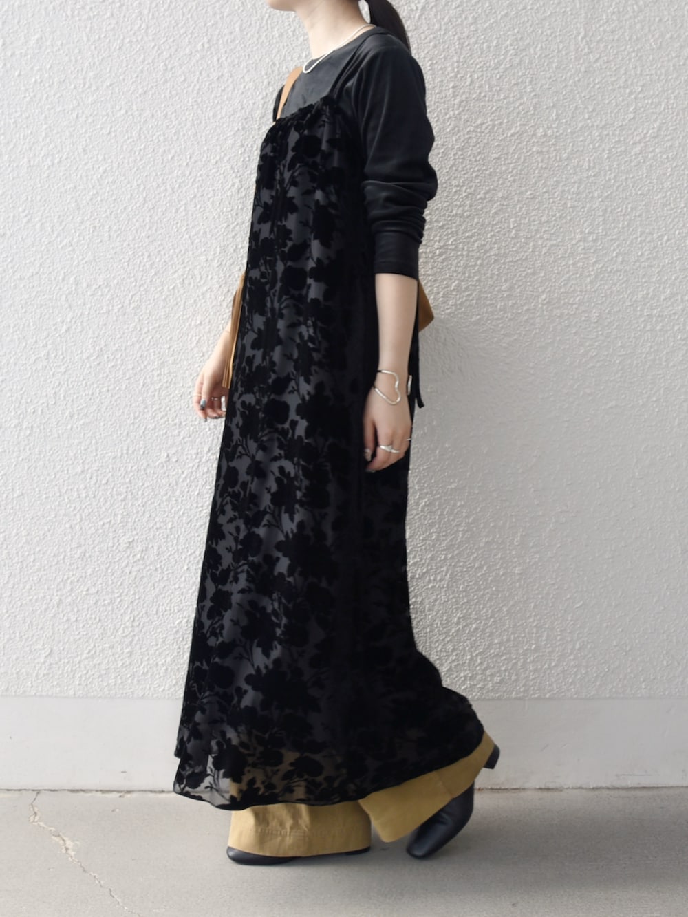 イエロー系のトートバッグ、ブラック系のTシャツ/カットソー、ベージュ系のその他パンツを着用したレディースの冬コーディネートの2枚目の写真