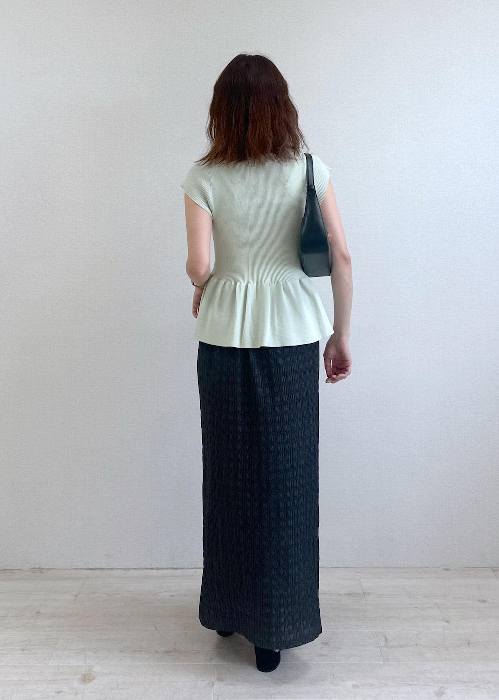 ブラック系のショルダーバッグ、グレー系のスカート、グリーン系のカーディガン/ボレロを着用したレディースの夏コーディネートの3枚目の写真