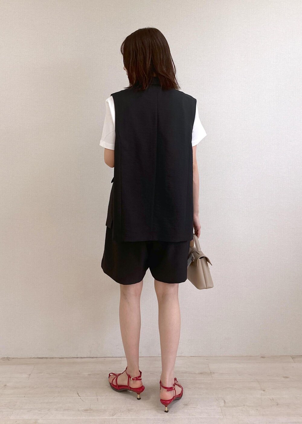 ベージュ系のショルダーバッグ、レッド系のサンダル、ホワイト系のTシャツ/カットソーを着用したレディースの春コーディネートの3枚目の写真