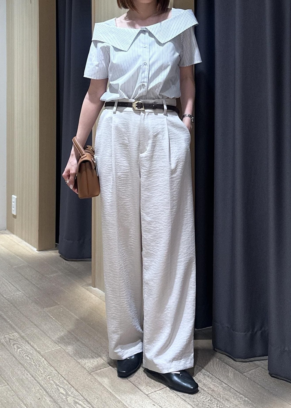 イエロー系のショルダーバッグ、ブラック系のパンプス、ホワイト系のその他パンツを着用したレディースの夏コーディネートの3枚目の写真