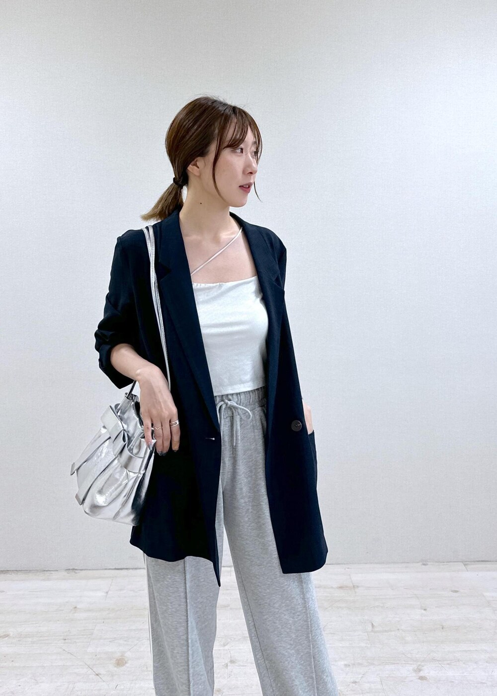 シルバー系のキャミソール、ブルー系のテーラードジャケット、その他のサンダルを着用したレディースの夏コーディネートの4枚目の写真