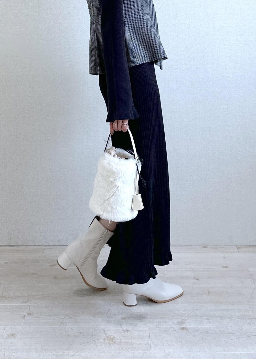 ホワイト系のショルダーバッグ、ホワイト系のブーツ、ブラック系のワンピースを着用したレディースの秋コーディネートの4枚目の写真