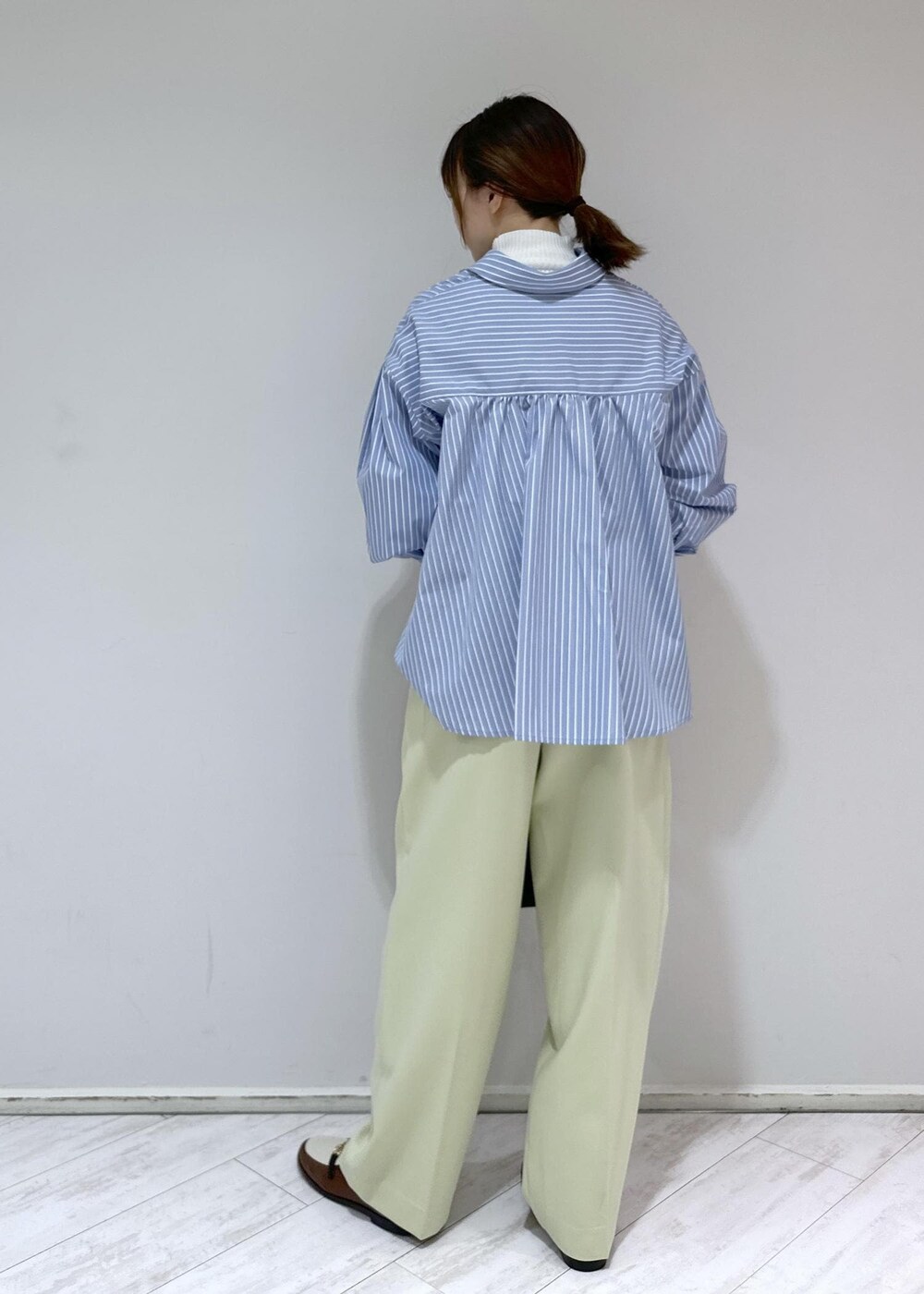 ブラウン系のローファー、ブラック系のハンドバッグ、ホワイト系のニット/セーターを着用したレディースの冬コーディネートの3枚目の写真