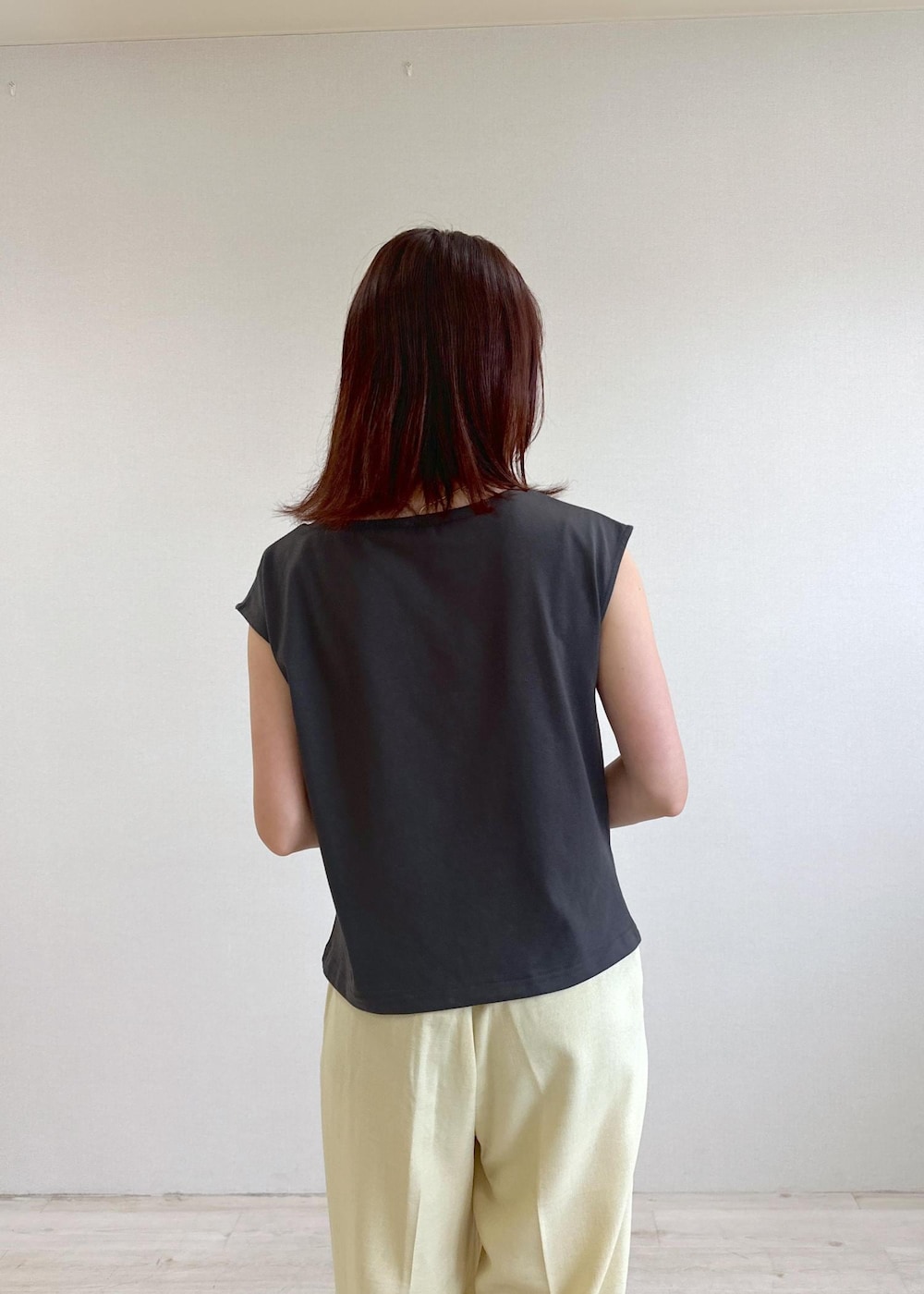 ホワイト系のショルダーバッグ、ブラック系のサンダル、イエロー系のスラックスを着用したレディースの夏コーディネートの7枚目の写真