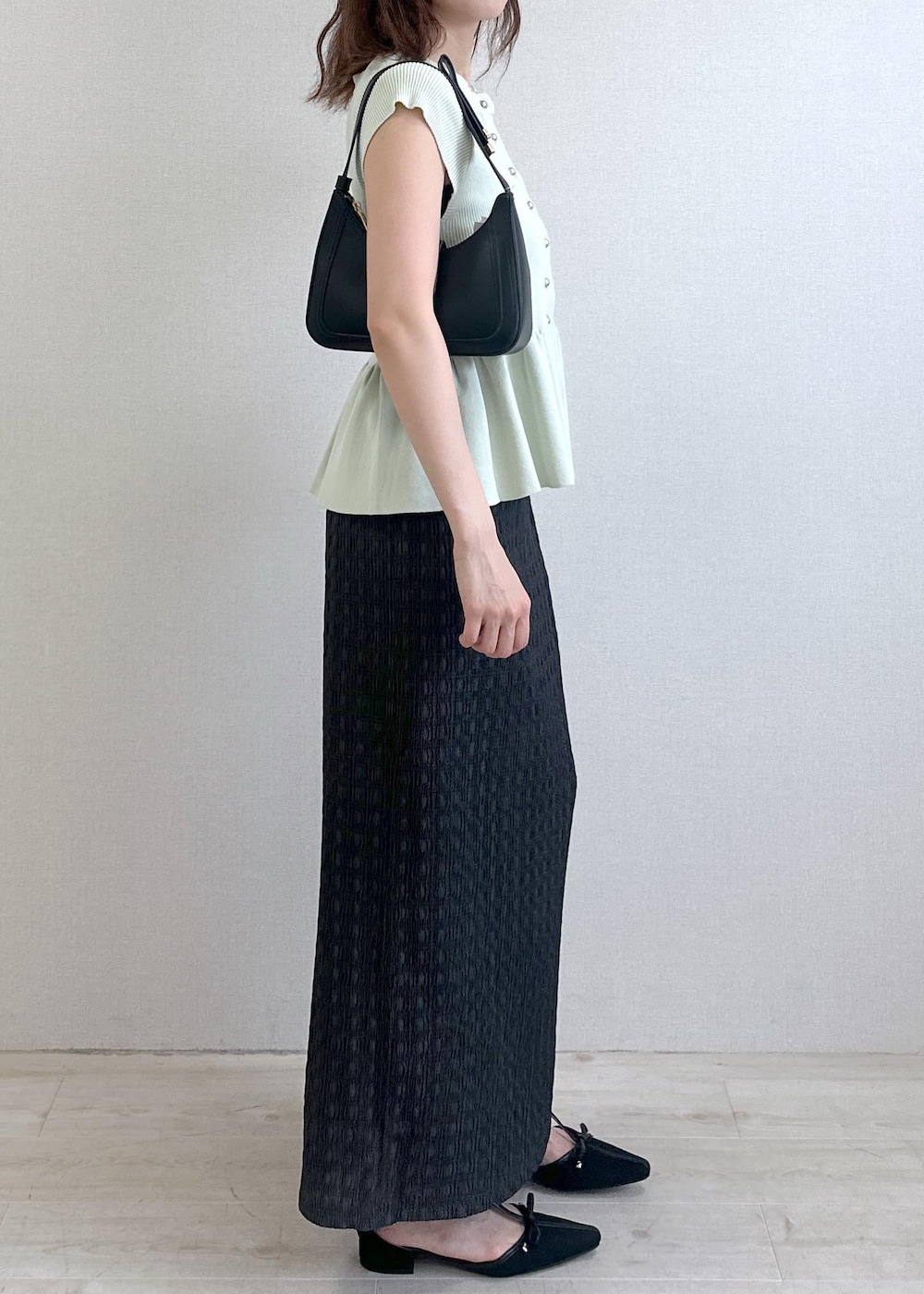 ブラック系のショルダーバッグ、グレー系のスカート、グリーン系のカーディガン/ボレロを着用したレディースの夏コーディネートの5枚目の写真