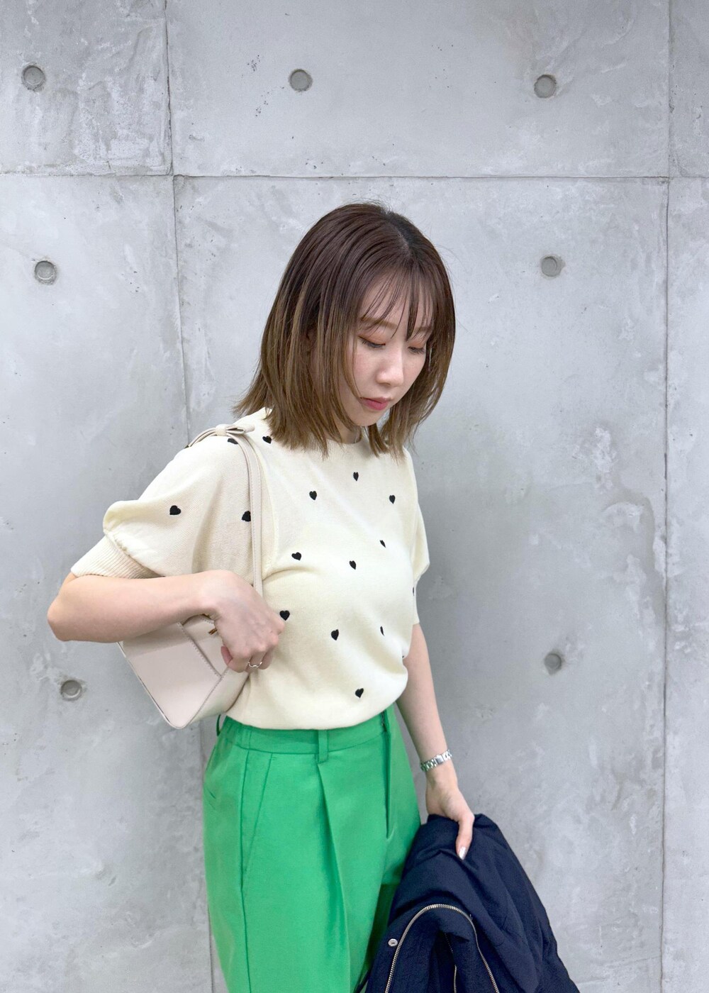 シルバー系のパンプス、ブルー系のマウンテンパーカー、ホワイト系のニット/セーターを着用したレディースの春コーディネートの2枚目の写真