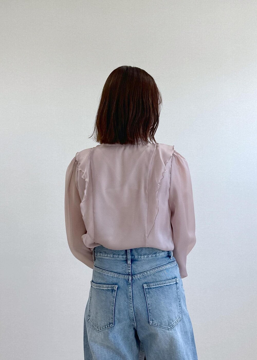 ブルー系のデニムパンツ、ブラック系のパンプス、グレー系のショルダーバッグを着用したレディースの春コーディネートの6枚目の写真