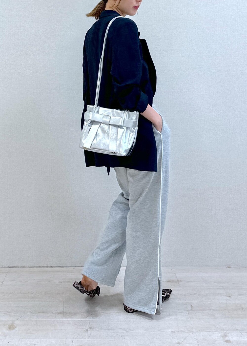 シルバー系のキャミソール、ブルー系のテーラードジャケット、その他のサンダルを着用したレディースの夏コーディネートの3枚目の写真