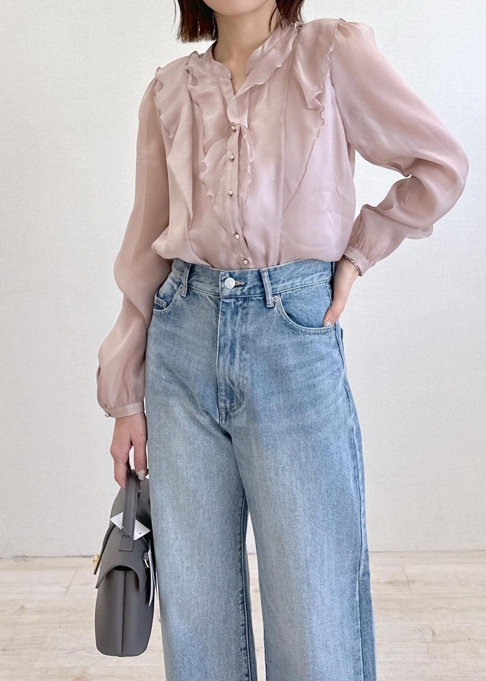 ブルー系のデニムパンツ、ブラック系のパンプス、グレー系のショルダーバッグを着用したレディースの春コーディネートの4枚目の写真