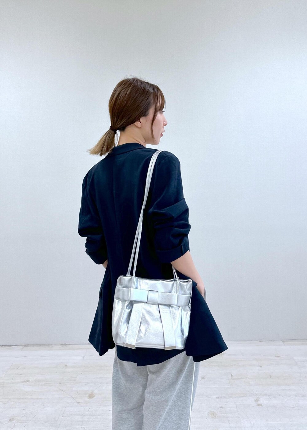 シルバー系のキャミソール、ブルー系のテーラードジャケット、その他のサンダルを着用したレディースの夏コーディネートの5枚目の写真