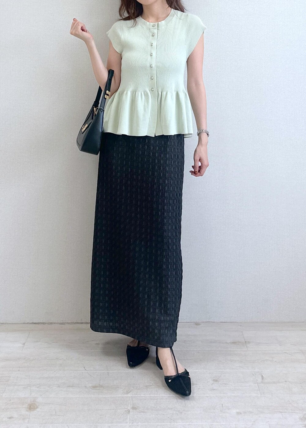 ブラック系のショルダーバッグ、グレー系のスカート、グリーン系のカーディガン/ボレロを着用したレディースの夏コーディネートの4枚目の写真