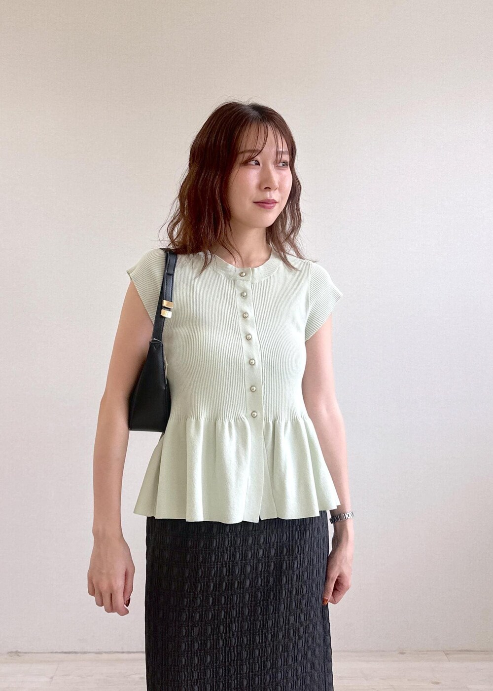 ブラック系のショルダーバッグ、グレー系のスカート、グリーン系のカーディガン/ボレロを着用したレディースの夏コーディネートの6枚目の写真