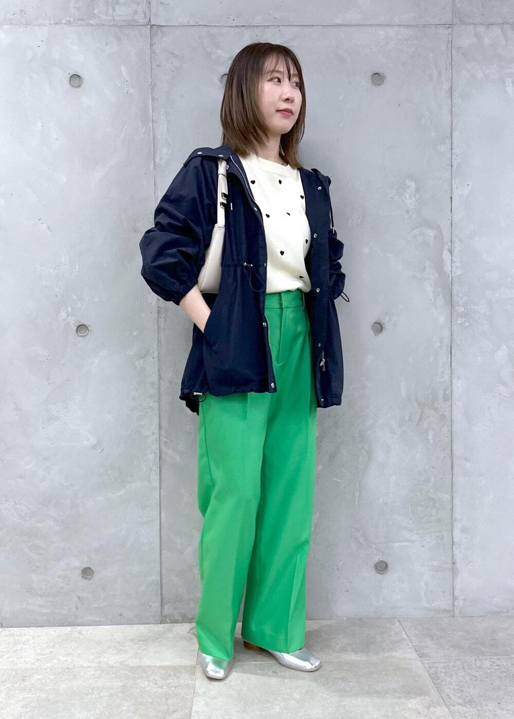 シルバー系のパンプス、ブルー系のマウンテンパーカー、ホワイト系のニット/セーターを着用したレディースの春コーディネートの3枚目の写真