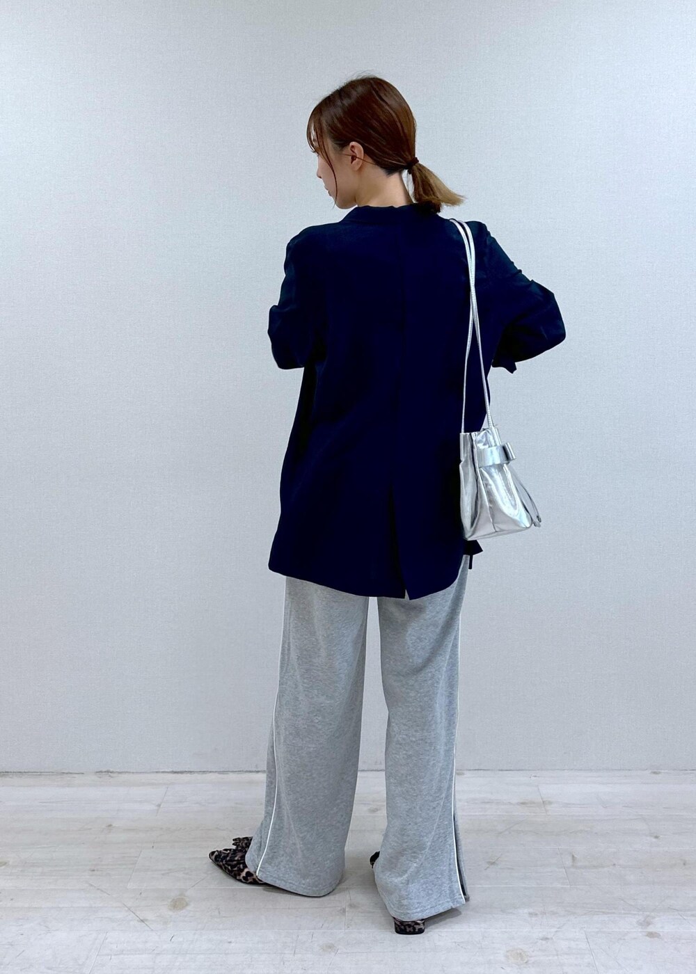 シルバー系のキャミソール、ブルー系のテーラードジャケット、その他のサンダルを着用したレディースの夏コーディネートの2枚目の写真