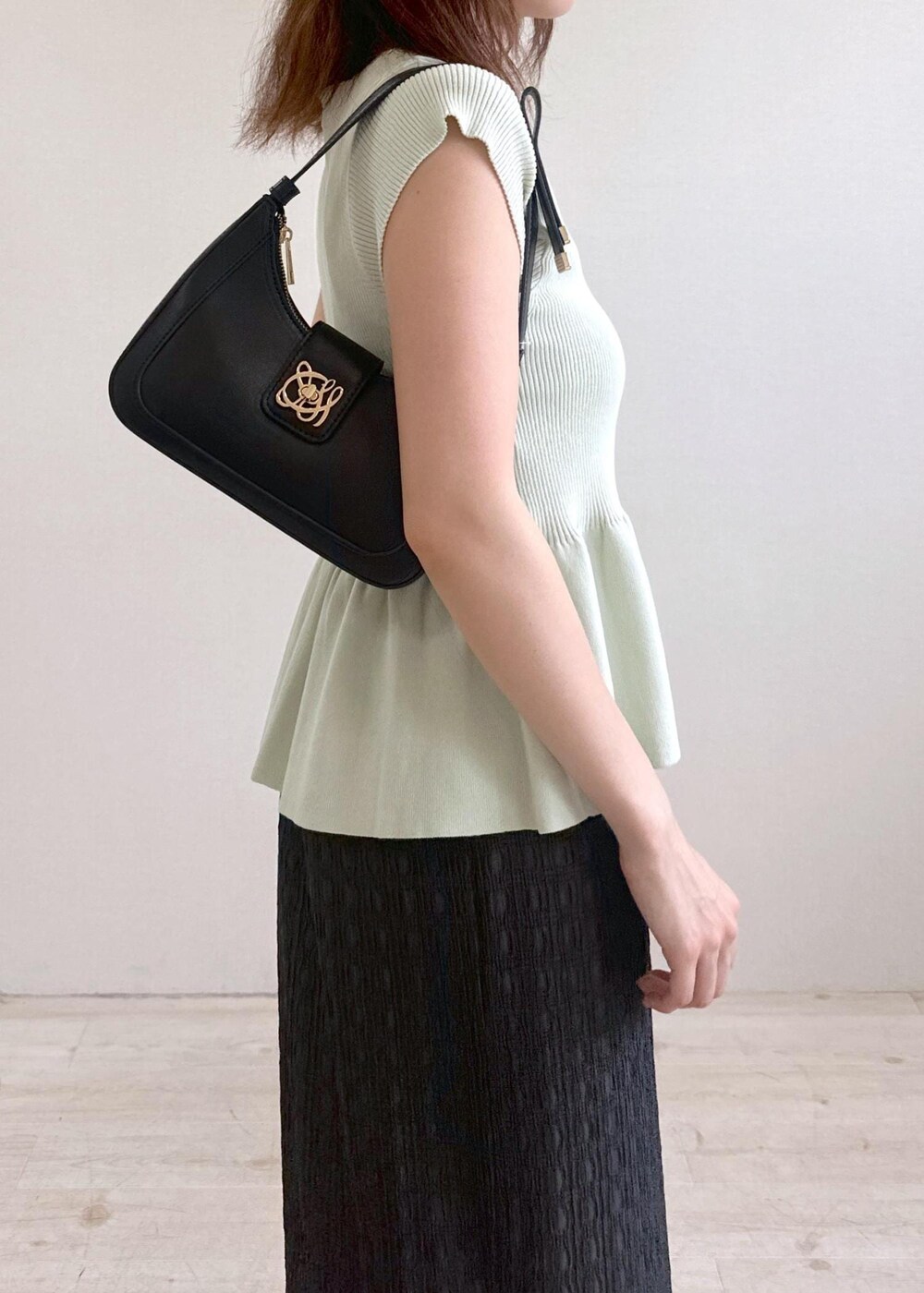 ブラック系のショルダーバッグ、グレー系のスカート、グリーン系のカーディガン/ボレロを着用したレディースの夏コーディネートの7枚目の写真