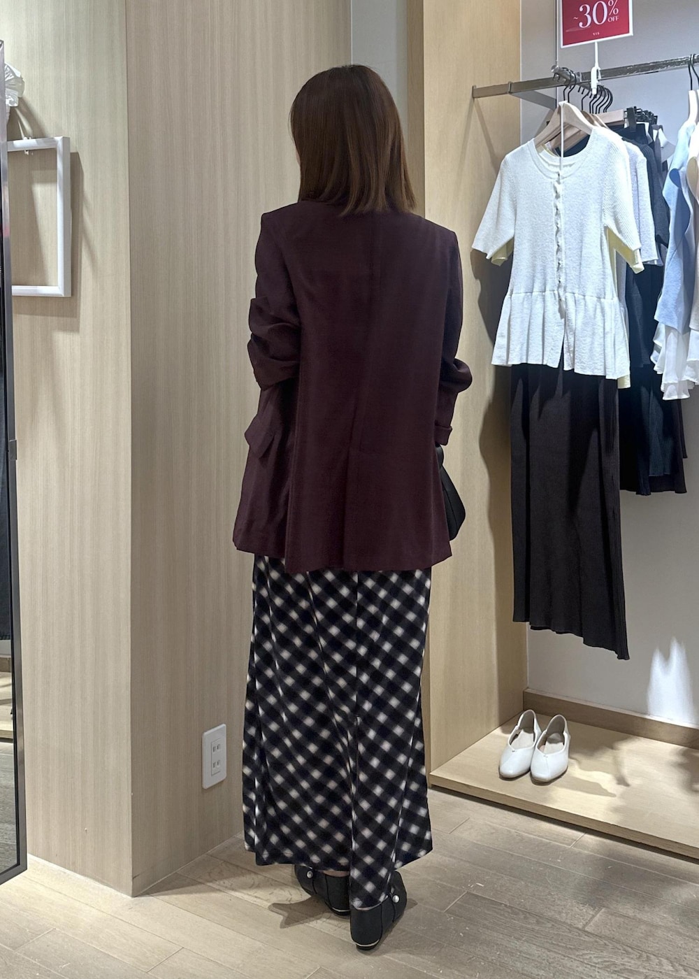 ブラック系のショルダーバッグ、ブラック系のパンプス、ブラウン系のテーラードジャケットを着用したレディースの夏コーディネートの2枚目の写真