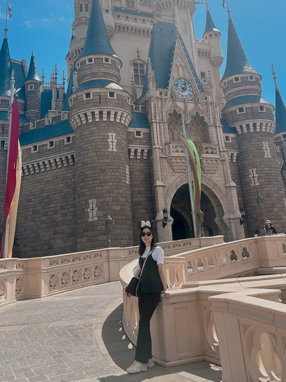 ブラック系のデニムパンツ、ブラック系のキャミソール、ホワイト系のスニーカーを着用したレディースの秋コーディネートの2枚目の写真