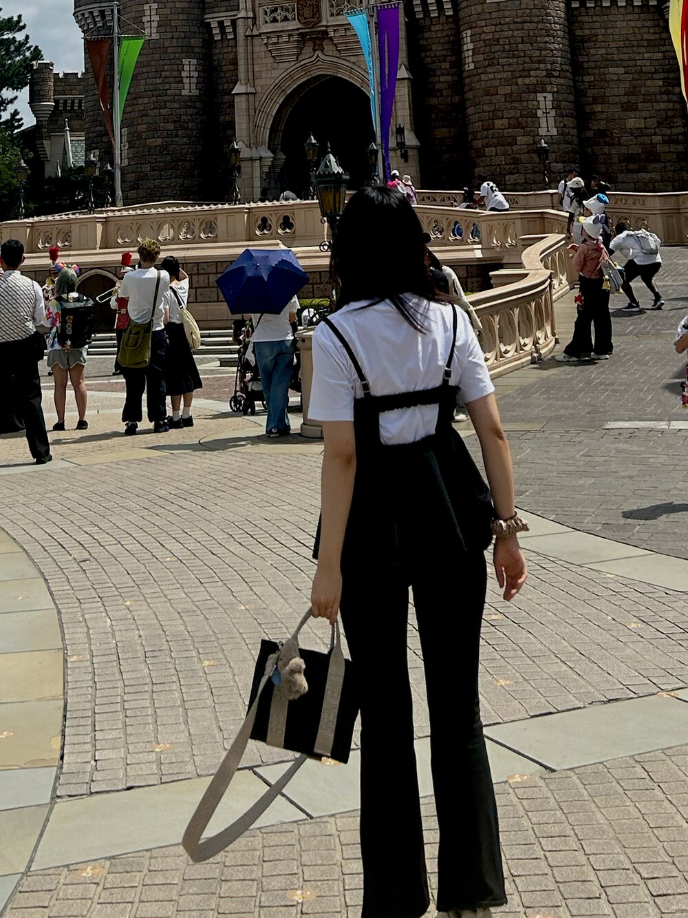 ブラック系のデニムパンツ、ブラック系のキャミソール、ホワイト系のスニーカーを着用したレディースの秋コーディネートの3枚目の写真