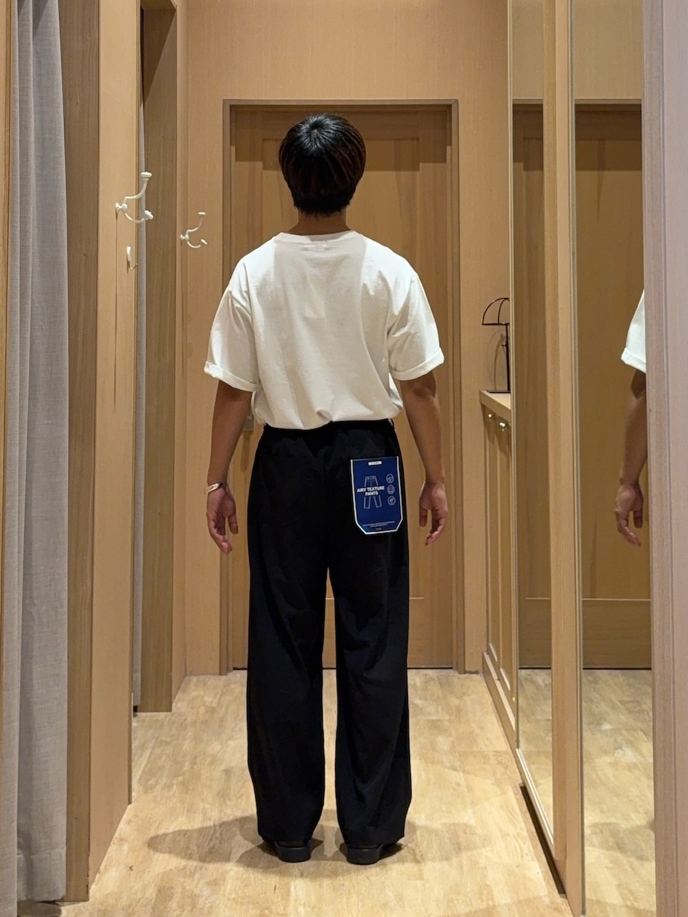 ホワイト系のTシャツ/カットソー、ブラック系のスラックス、グリーン系のサングラスを着用したメンズの夏コーディネートの3枚目の写真