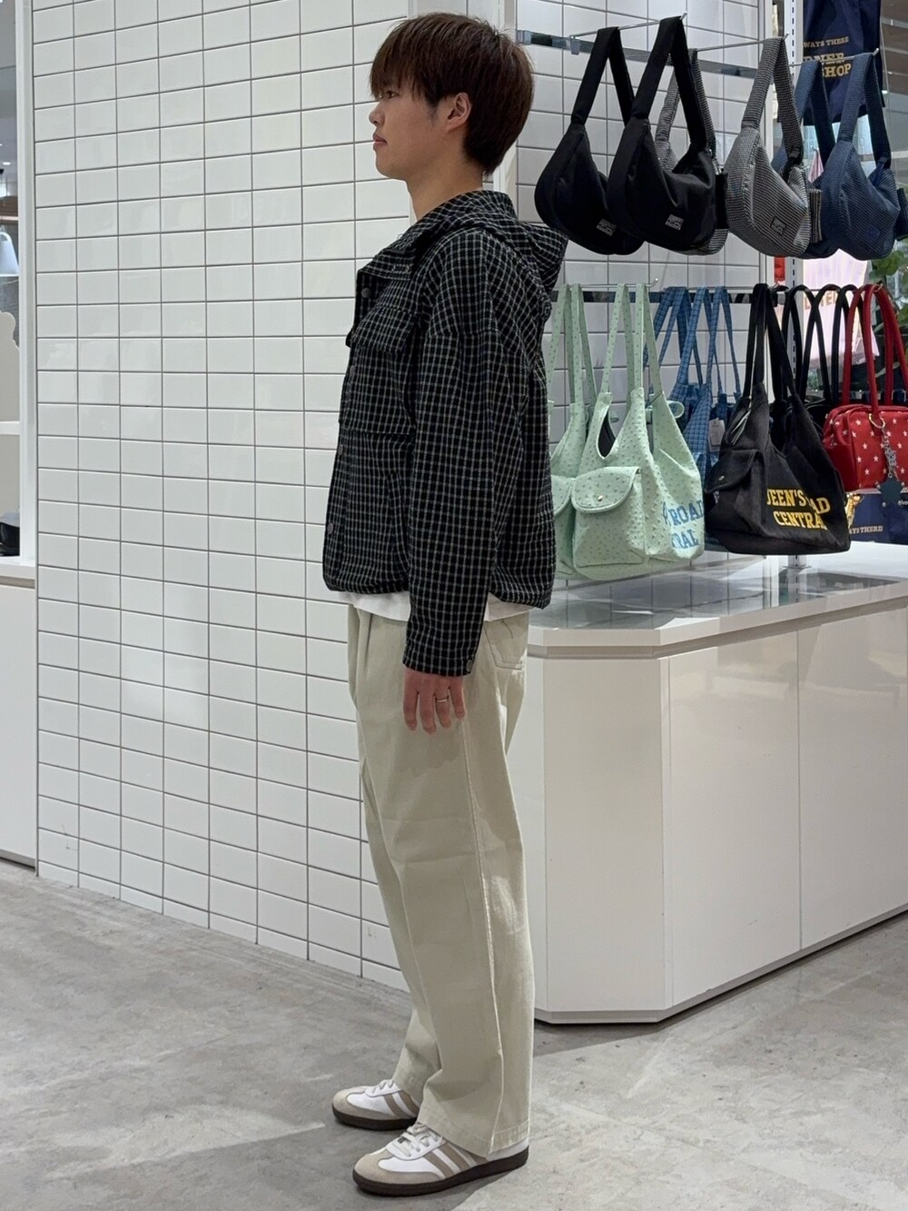 ブラック系のパーカー、ホワイト系のチノパンツを着用したメンズの春コーディネートの2枚目の写真