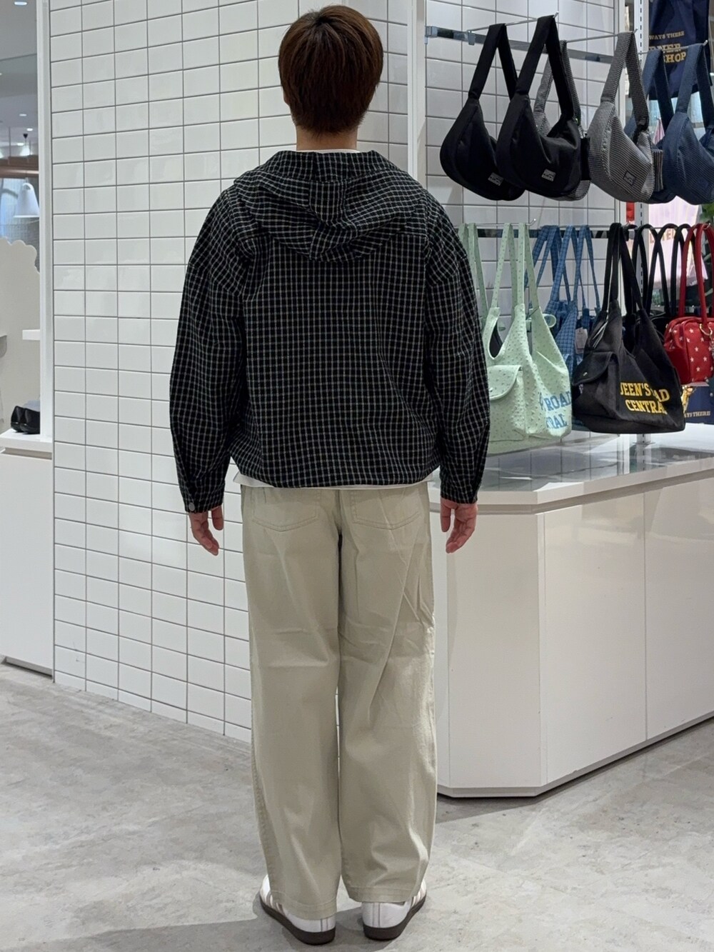 ブラック系のパーカー、ホワイト系のチノパンツを着用したメンズの春コーディネートの3枚目の写真