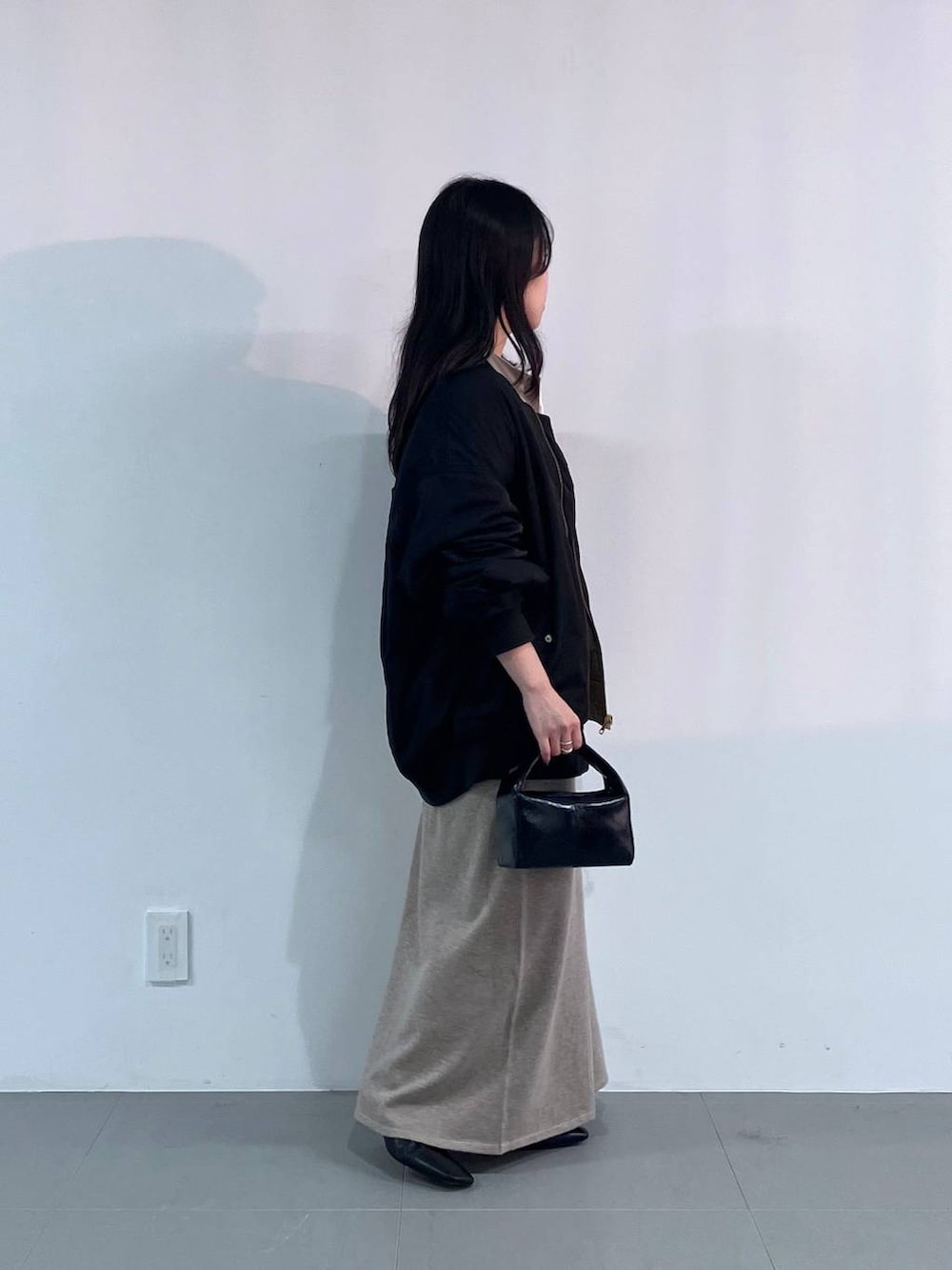 ブラック系のトートバッグ、ブラック系のMA-1、ベージュ系のワンピースを着用したレディースの秋コーディネートの2枚目の写真