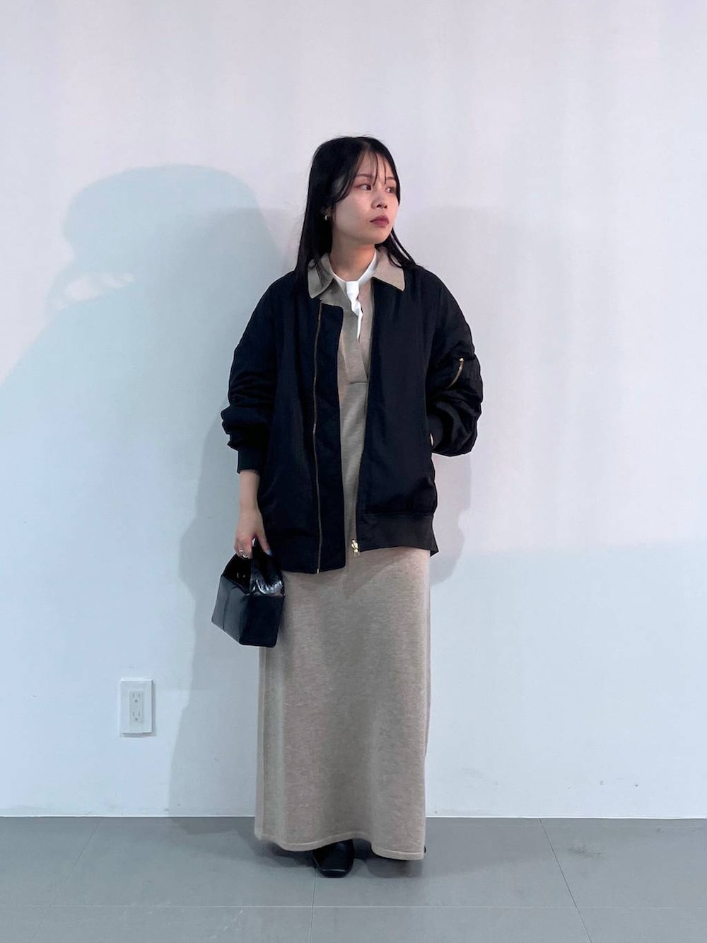 ブラック系のトートバッグ、ブラック系のMA-1、ベージュ系のワンピースを着用したレディースの秋コーディネートの4枚目の写真