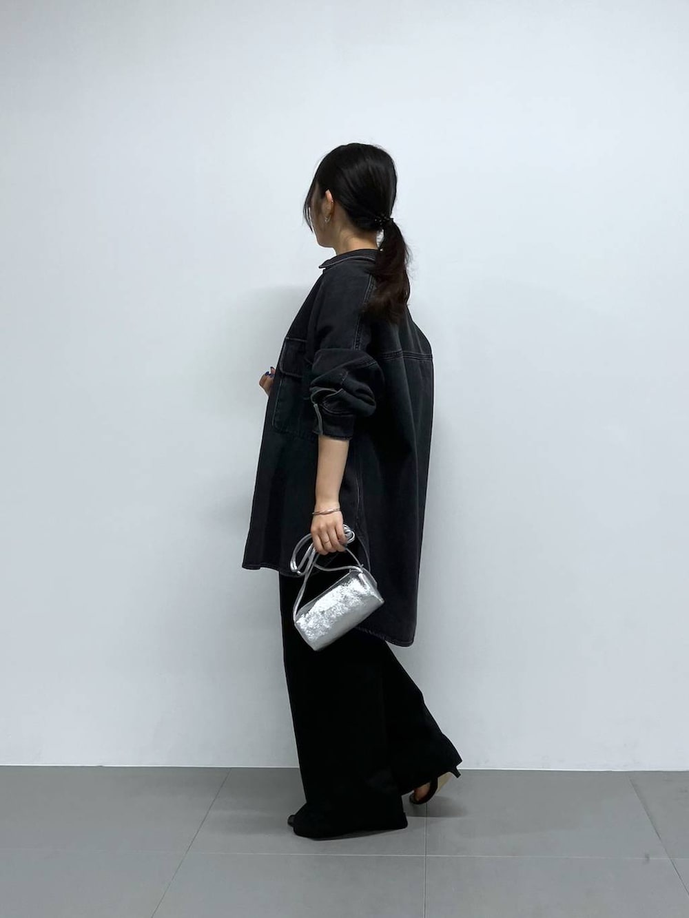 シルバー系のショルダーバッグ、ブラック系のチノパンツ、ブラック系のTシャツ/カットソーを着用したレディースの秋コーディネートの3枚目の写真