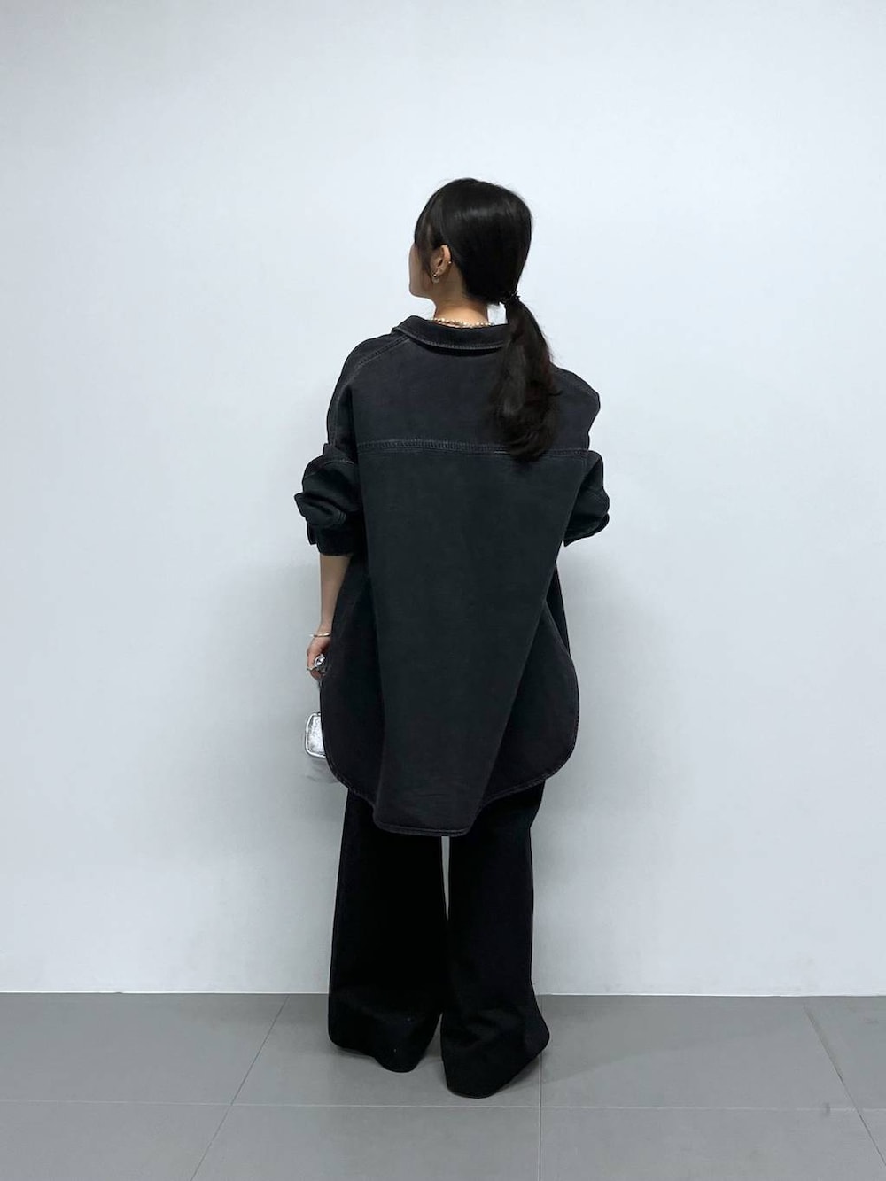 シルバー系のショルダーバッグ、ブラック系のチノパンツ、ブラック系のTシャツ/カットソーを着用したレディースの秋コーディネートの4枚目の写真