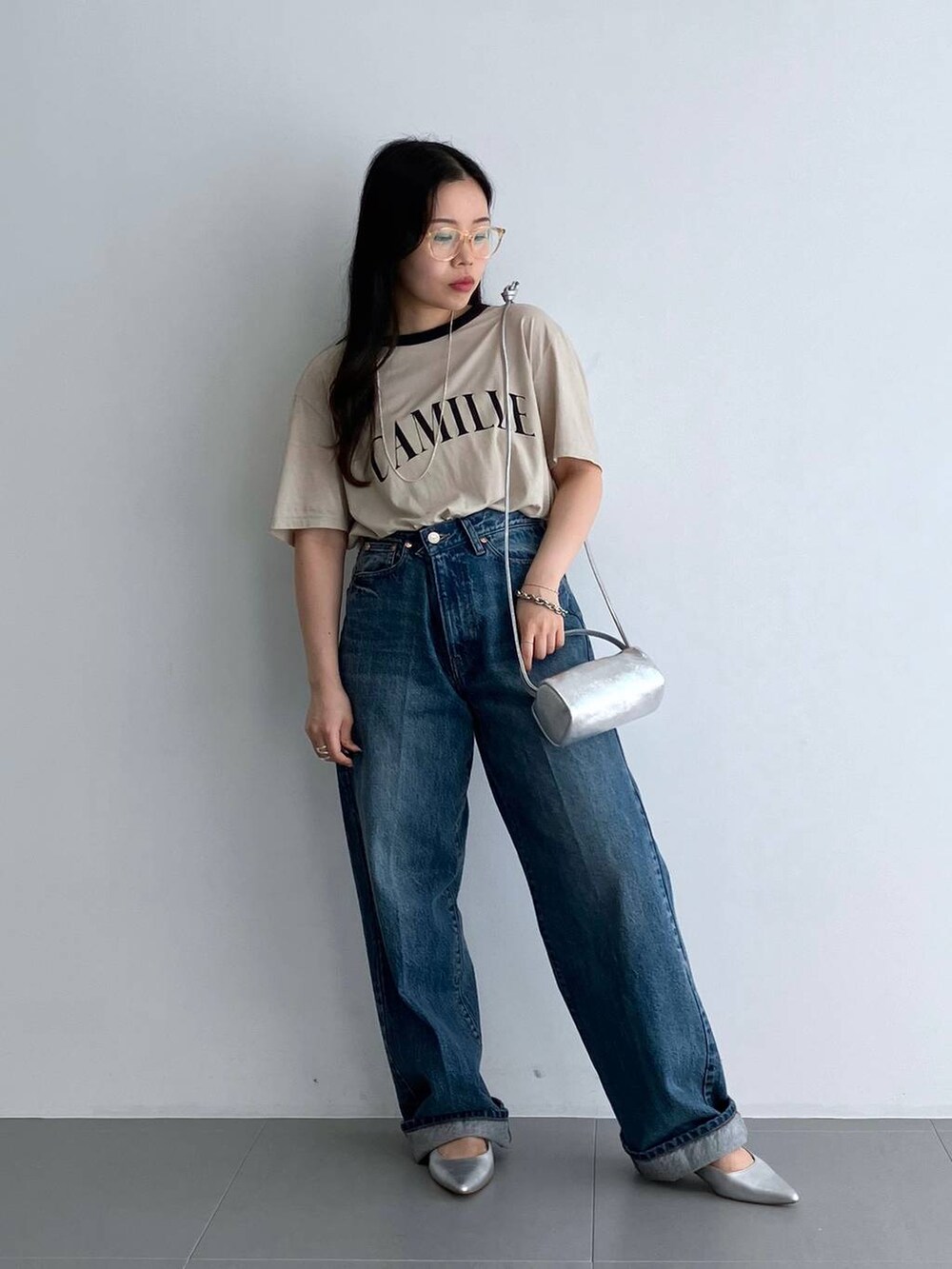 ブルー系のデニムパンツ、シルバー系のパンプス、ベージュ系のTシャツ/カットソーを着用したレディースの夏コーディネートの2枚目の写真
