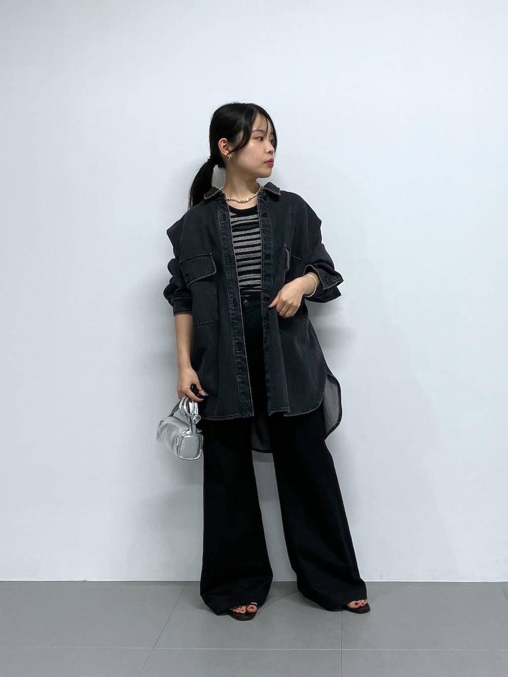 シルバー系のショルダーバッグ、ブラック系のチノパンツ、ブラック系のTシャツ/カットソーを着用したレディースの秋コーディネートの5枚目の写真