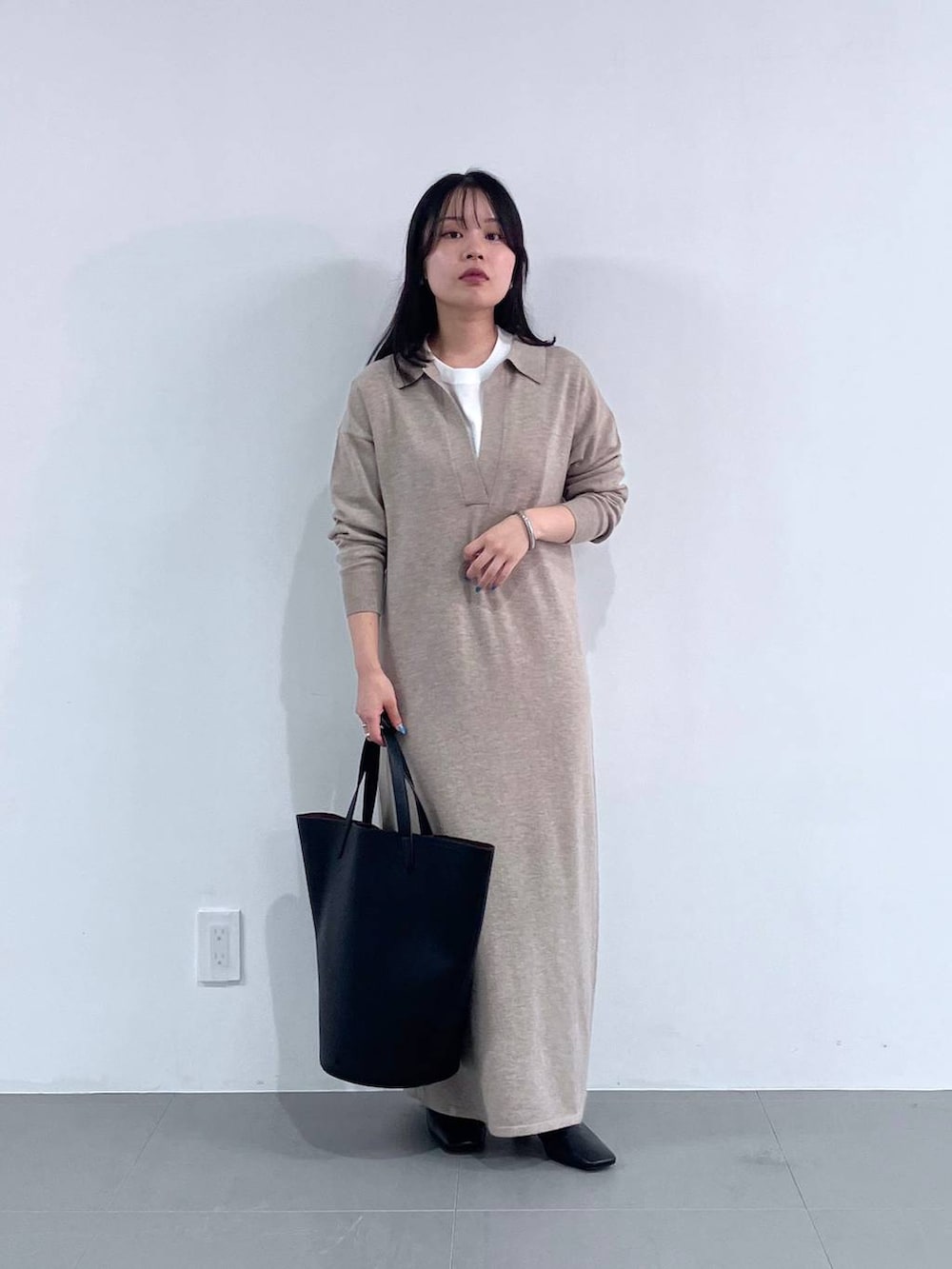 ブラック系のトートバッグ、ブラック系のMA-1、ベージュ系のワンピースを着用したレディースの秋コーディネートの5枚目の写真