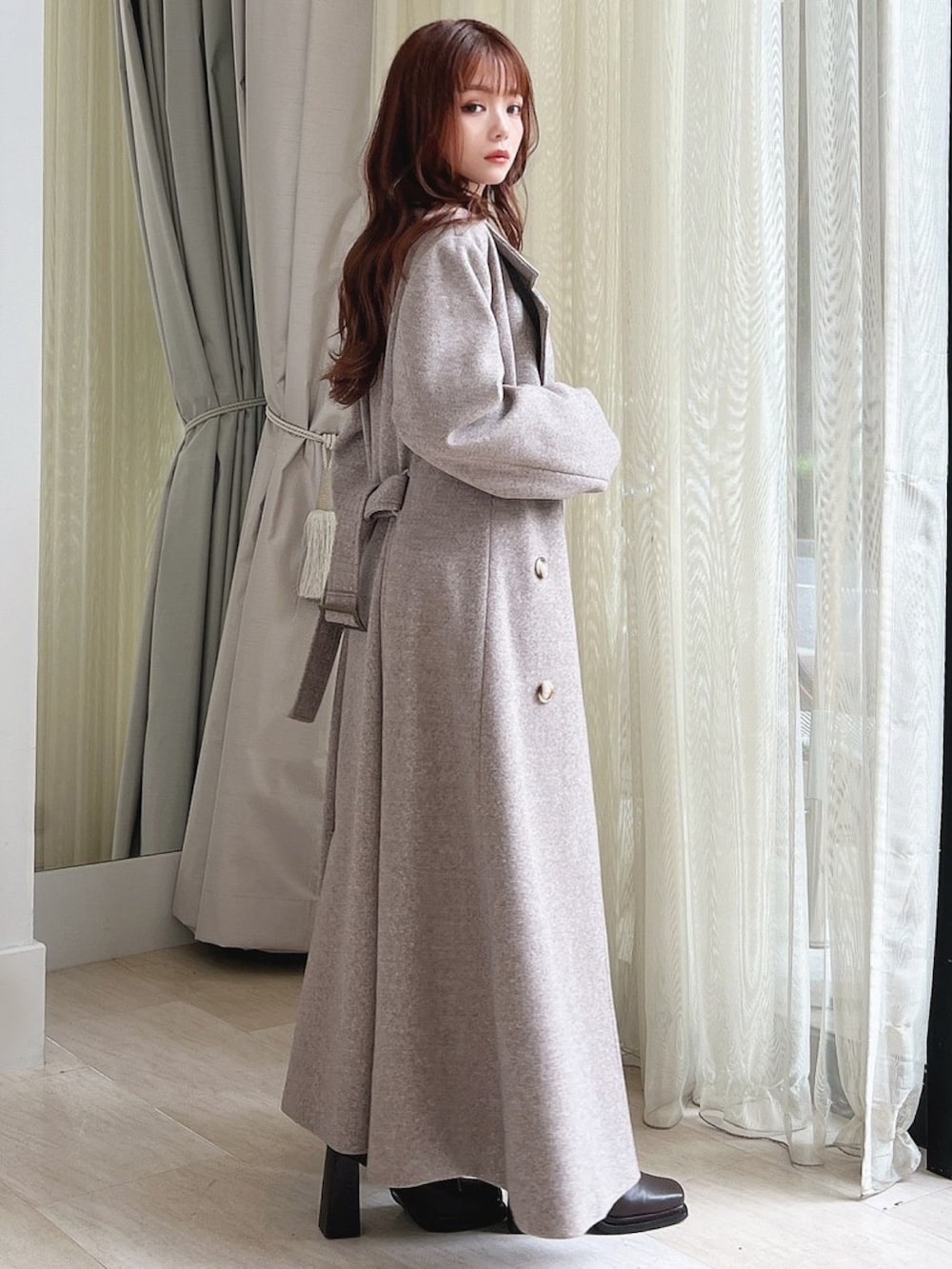 ブラウン系のブーツ、ブラウン系のチェスターコート、ブラック系のニット/セーターを着用したレディースの秋コーディネートの2枚目の写真