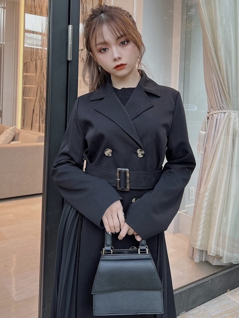 ブラック系のトレンチコート、ブラック系のワンピース、ブラック系のブーツを着用したレディースの冬コーディネートの4枚目の写真