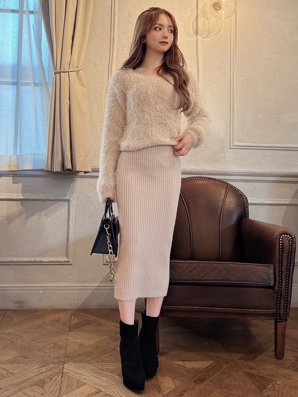 ベージュ系のワンピース、ブラック系のブーツを着用したレディースの冬コーディネートの2枚目の写真