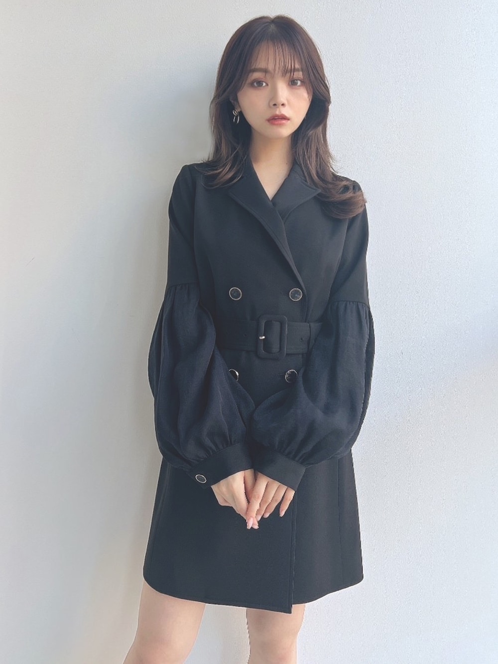 ブラック系のワンピース、ブラック系のハンドバッグを着用したレディースの冬コーディネートの3枚目の写真