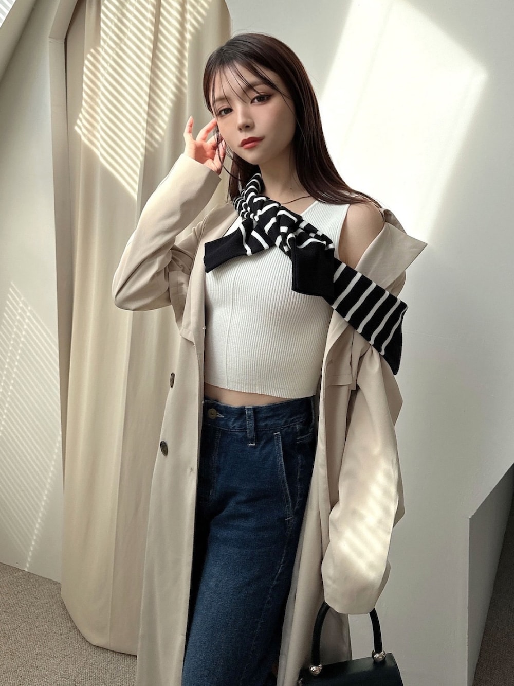 ベージュ系のトレンチコート、その他のカーディガン/ボレロ、ブルー系のデニムパンツを着用したレディースの冬コーディネートの5枚目の写真